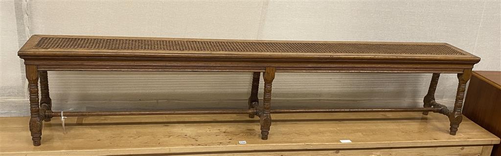 A long stool with canework seat, designed by Alfred Waterhouse for Blackmoor, Hampshire (a pair to one at Lotherton Hall), length 204cm